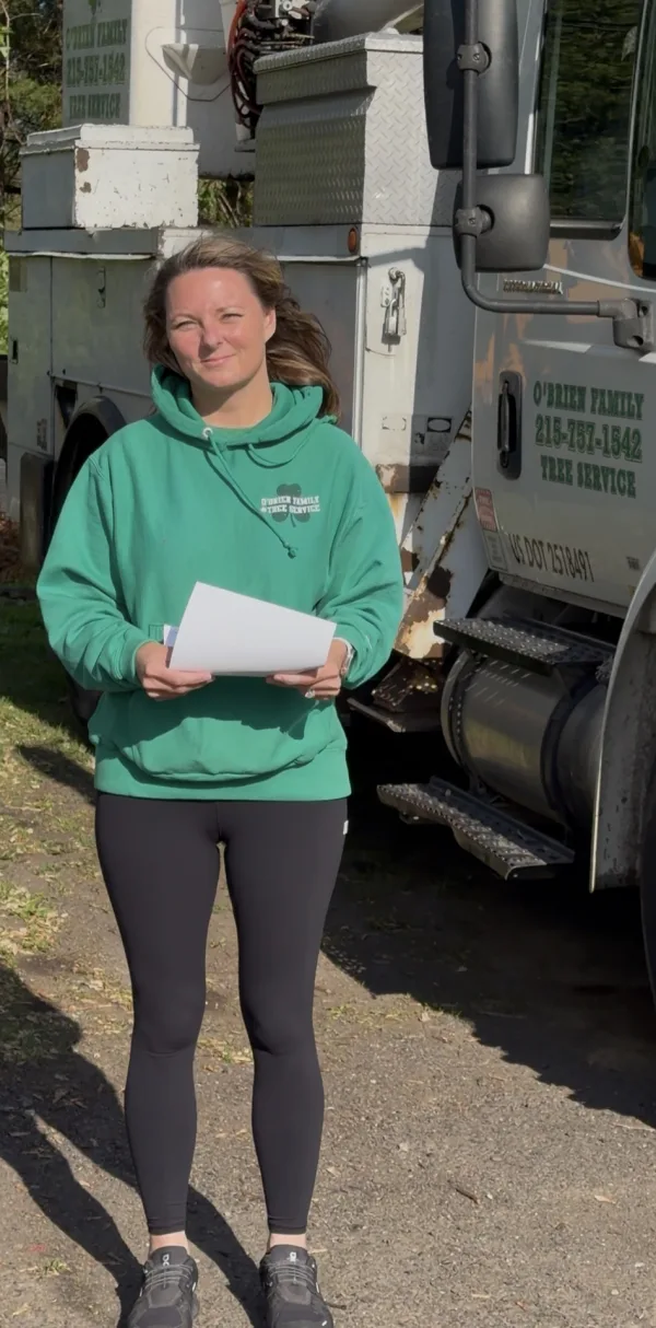 Jen O'Brien with estimate paperwork in front of the O'Brien Tree Care truck